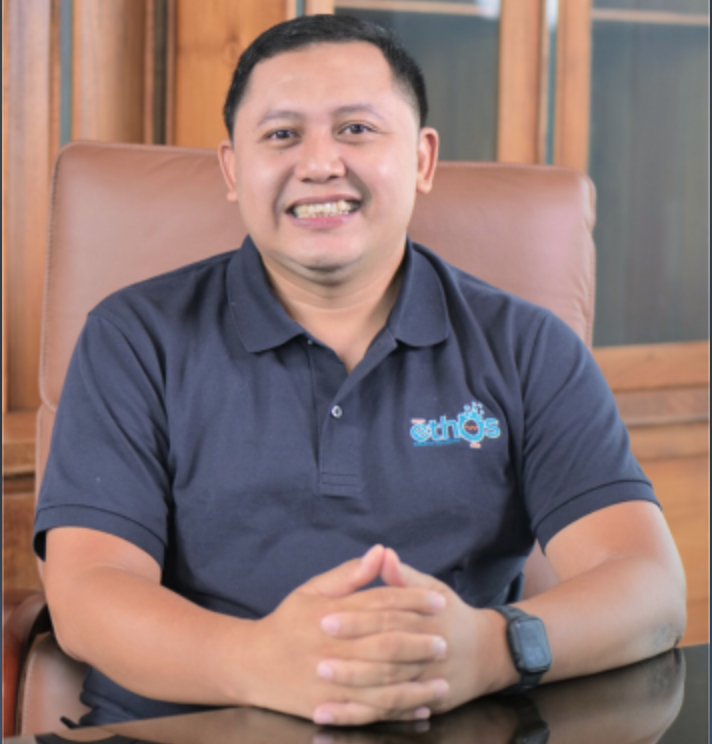 Professional headshot of Indonesian male finance executive, formal suit, neutral studio background